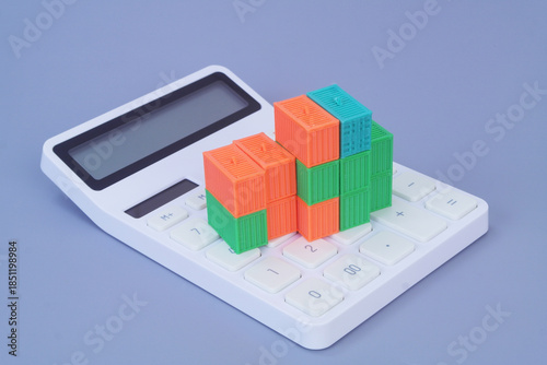 Many cargo containers on calculator on grey background. Shipping and transportation cost  concept.