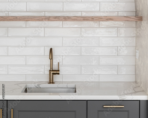 Billede på lærred A modern kitchen sink detail with a brass faucet against a white subway tile backsplash, floating natural wood shelf, dark gray cabinets, and pattern wallpaper
