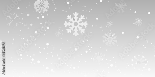 Gentle snowfall with delicate white snowflakes against a soft gray background