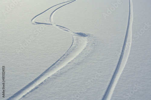 Bicycle tracks in white snow. A sunny winter day. Outdoor recreation.