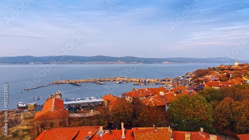 Red tiled roofs of the houses in the coastal park of Nessebar, Bulgaria. Approaching the quay with a berth and multiple boats and yachts.