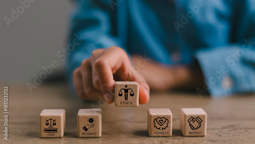 Code of conduct in business concept. Wooden blocks with code of conduct icons; code, integrity, honesty, respect, and ethics, the foundation of a strong corporate code of conduct. Corporate ethics. 