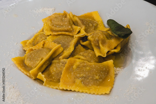 Delicious plate of tortelli di zucca with sage on a white plate.