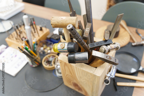 Tablou pe pânză Various professional jewelry hammers and files stored in a wooden block on a workbench