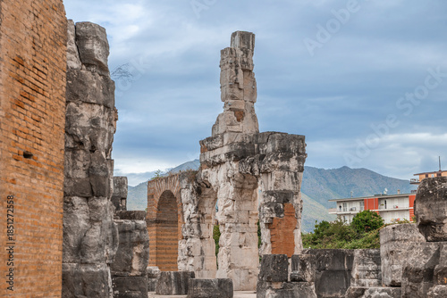 Foto Ancient Roman ruins of the Capua Amphitheater with mountain backdrop and modern