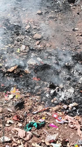 Wallpaper Mural Belagavi, Karnataka, India - December 20, 2025: Garbage burning in an open area releasing smoke, showing pollution, waste management issues, and environmental hazards in rural surroundings. Torontodigital.ca