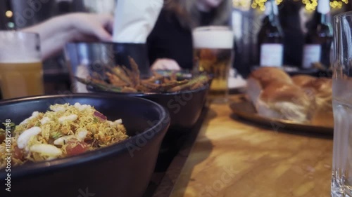 Indian Curry Dishes on Restaurant Table with Beer in Birmingham, England.
Close-up view of freshly served Indian curry dishes on a wooden table inside a modern Indian restaurant in Birmingham, England