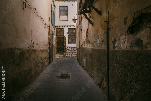 Εκτύπωση καμβά A quiet narrow alley in the old city of Damascus, lined with weathered stone walls, traditional houses, and soft natural light reflecting the city’s historic character