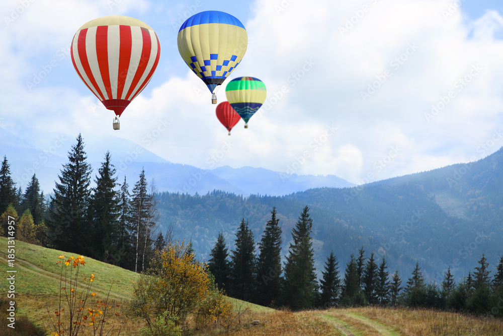 Fototapeta premium Colorful hot air balloons flying above mountains
