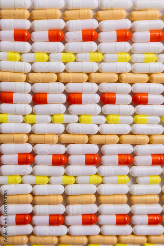 Pattern of many multicolored pills. Concept of uncontrolled supplement use. Selective focus, vertical banner