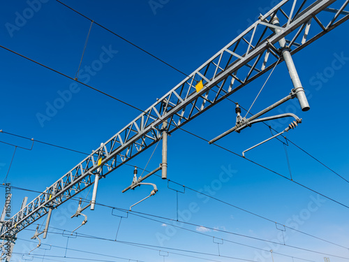 Railway overhead lines on blue sky, electrification system catenary