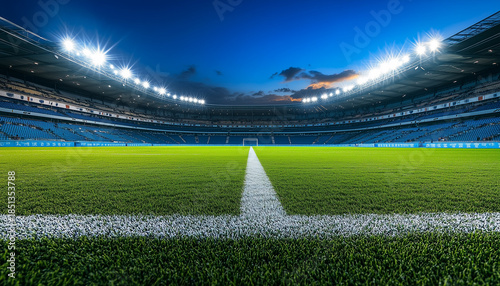 Illuminated football stadium with green grass and white markings.