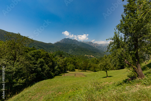 vista panoramica su di un ambiente naturale tra le montagne della regione Lombardia, di giorno, in estate, con cielo sereno