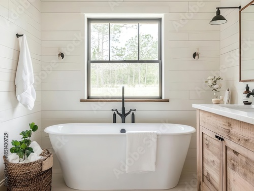 Farmhousestyle bathroom with modern freestanding tub and shiplap wall detail