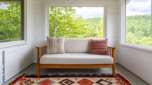 Rustic sunroom with modern sofa, natural light, and vintage rug