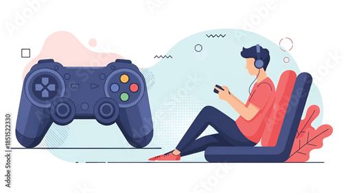 Young gamer seated on floor chair with headphones, holding controller, giant gamepad graphic.vibrant