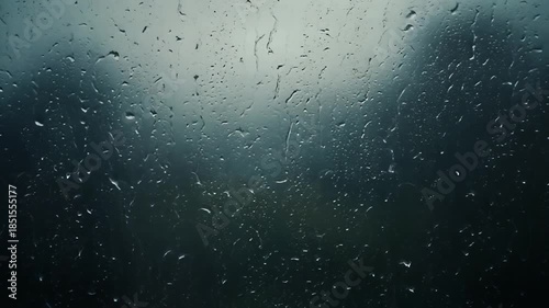 Rainy window with water droplets and blurred background at night