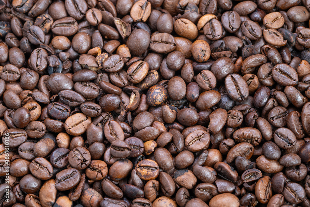 Naklejka premium Background composed of scattered matte finish medium roast coffee beans, Abundant bulk of roasted coffee beans arranged in uniform pattern for packaging backdrop