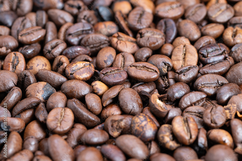 Fototapeta premium Detailed medium roast beans displaying glossy finish and warm hues, Macro image of varying roasted coffee beans showcasing rich brown shades and matte surface texture