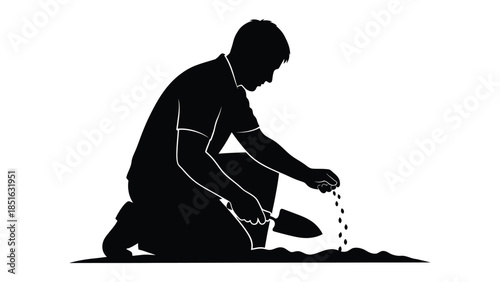 Silhouette of a gardener kneeling down sowing seeds into the soil with a small trowel tool