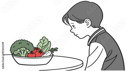 Young boy looking at a bowl of fresh vegetables.