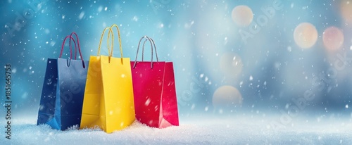 The shopping bags in snowy winter scene with festive bokeh lights