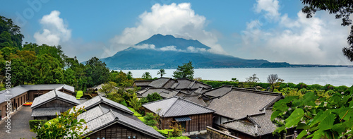The roofs of ancient japanese houses with the iconic Sakurajima volcano in the background, Sengan-en, Kagoshima, Kyushu island, Japan