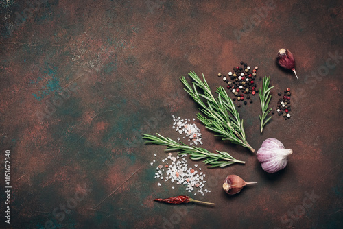 Cooking ingredients, spices, and herbs. Dark brown culinary background. Top view, flat lay, copy space.