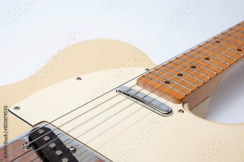 Six-string electric guitar, with a cream-colored wooden body and chrome-plated fittings.