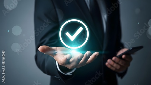 Businessman holding a glowing digital verification symbol above his open hand