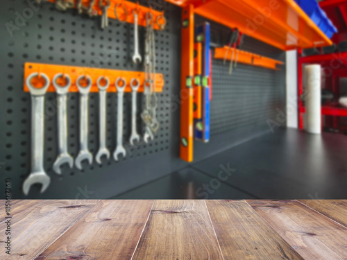 Wooden table top over blurry background of power tools on shelf display background.