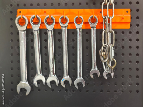 wrench set hanging on orange hanger over black board