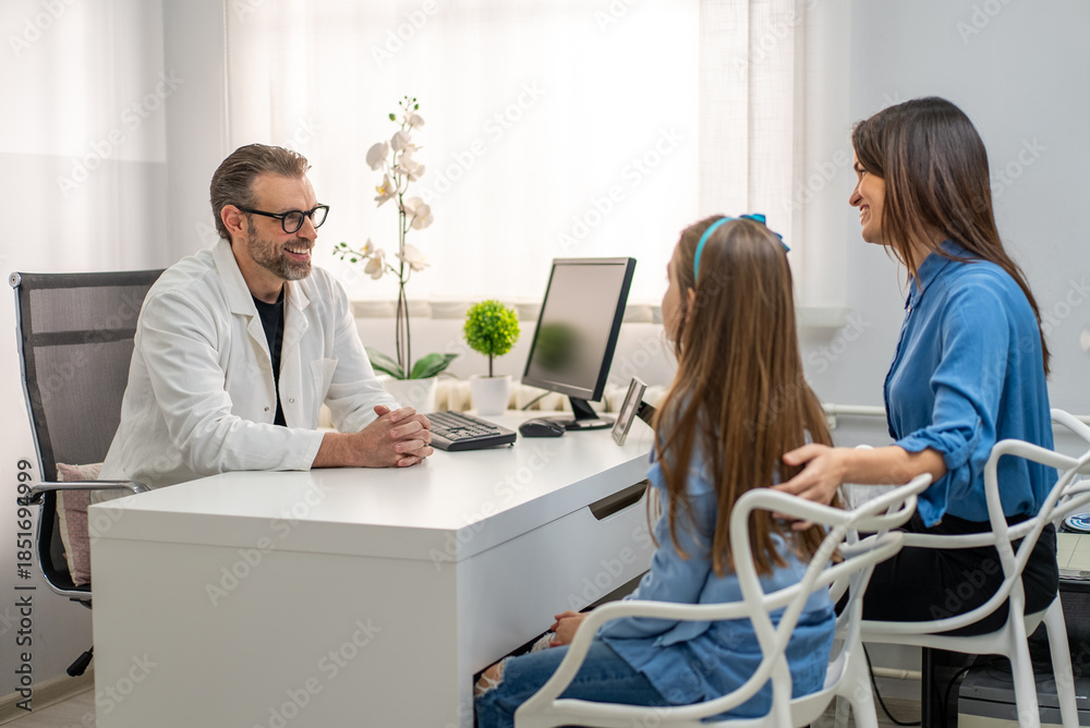 Obraz premium Doctor consulting with mother and child at desk in modern medical office