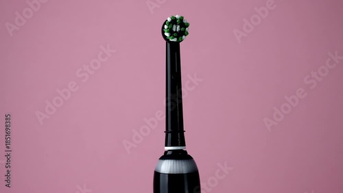 Electric toothbrush on pink background. Modern brush for professional oral hygiene.