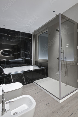 Luxury master bathroom with hardwood flooring, shower and bathtub.