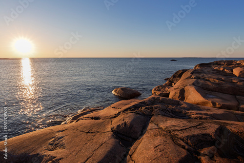 Scenic landscape of a rocky cliff by the sea in Åland Islands, Finland, on a sunny evening in the summer. Off the beaten path in the nature.