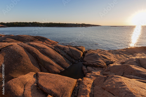 Scenic landscape of a rocky cliff by the sea in Åland Islands, Finland, on a sunny evening in the summer. Off the beaten path in the nature.
