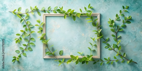 A simple wooden frame surrounded by vibrant green spring foliage on a textured light blue background, ideal for springtime announcements or invitations.