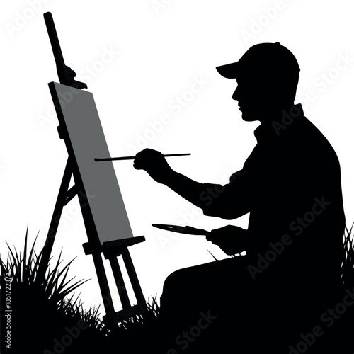 Silhouette of an artist painting on an easel outdoors.