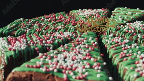 Close-up of a Christmas cake decorated with green icing and red and white sprinkles. Concept of holiday baking, Christmas celebration, and festive desserts.