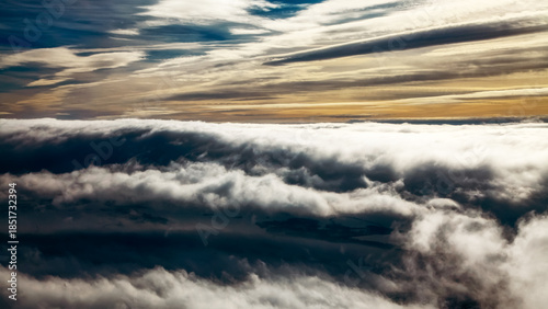 Bilde på lerret Dramatic cloud inversion above landscape with layered clouds and moody sky at su
