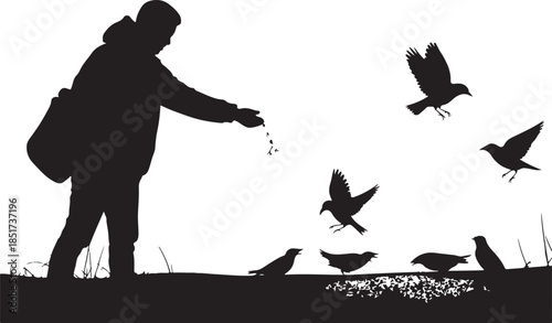 Silhouette of person feeding birds in winter landscape