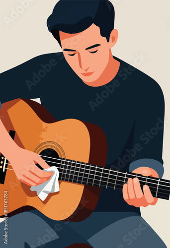 A young man carefully cleans his acoustic guitar with a white cloth
