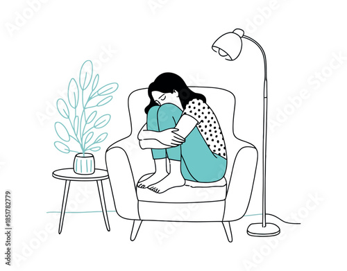 Young woman curled up in armchair, feeling lonely and withdrawn indoors