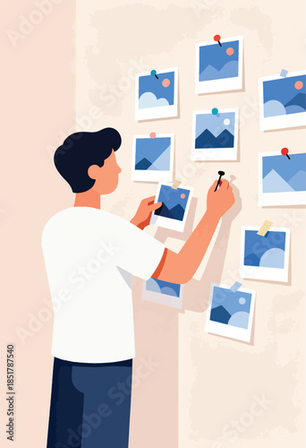 Person arranging landscape photos on a wall
