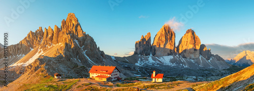 Panoramic view of mountain sunrise at Tre Cime di Lavaredo National park and rifugio Locatelli in Dolomites Alps, Trentino Alto Adige, Italy. Alpine landscape with huts and rock