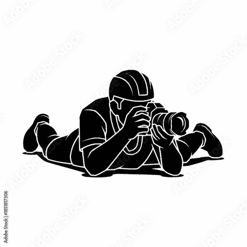 Silhouette of a photographer lying down, capturing a moment with a camera.
