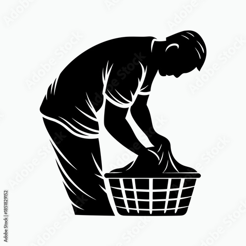 Man bending over laundry basket while sorting clothes at home  