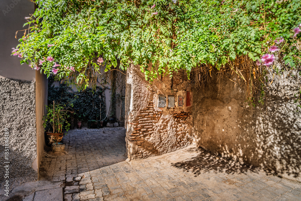 Naklejka premium Narrow Brick Tunnel Walkway With Group Of People Exploring Dim Underground Passage, The Soukh, Marrakesh, Morocco