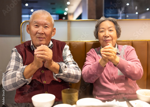 Happy Asian senior couple celebrating Chinese New Year in restaurant
